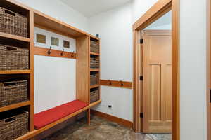 Mudroom with dark stone finish flooring and baseboards