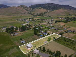 Aerial view of property's location with rural landscape, a mountain backdrop, and property boundaries highlighted