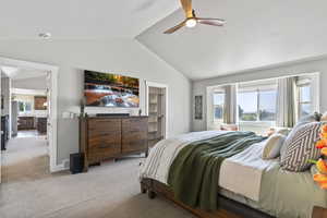 Bedroom with a spacious closet, multiple windows, lofted ceiling, carpet flooring, and ceiling fan