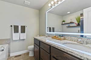 Full bathroom with a garden tub, double vanity, and a textured ceiling
