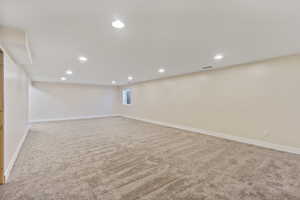 Below grade area featuring recessed lighting and light carpet