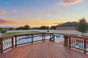 Deck at dusk featuring a fenced backyard