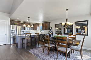 Dining area featuring a chandelier, dark wood-style floors, recessed lighting, and a textured ceiling