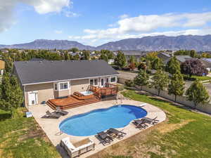 View of swimming pool with a patio, a deck with mountain view, a fenced backyard, and a diving board