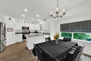 Dining area featuring lofted ceiling, recessed lighting, and dark wood finished floors