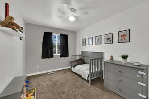 Bedroom featuring dark carpet, a ceiling fan, and a textured ceiling