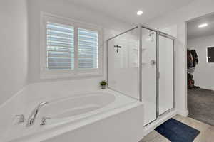 Full bath with a bath, a shower stall, a walk in closet, and recessed lighting