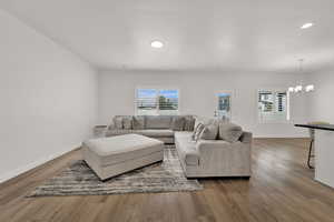 Living area featuring light wood finished floors, a chandelier, and recessed lighting
