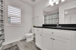 Bathroom featuring vanity, light wood-style flooring, and curtained shower
