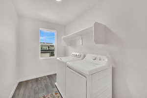 Laundry area featuring washer and dryer and light wood-style floors