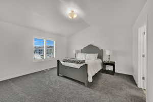 Bedroom featuring carpet flooring and vaulted ceiling