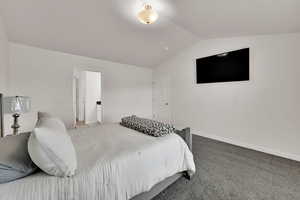 Bedroom with lofted ceiling and carpet