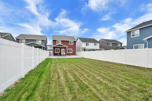 Fenced backyard with a patio area and a residential view