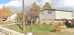 View of front of property with a front yard and brick siding