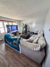 Living area with wood finished floors and a textured ceiling