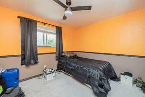 Carpeted bedroom with a ceiling fan