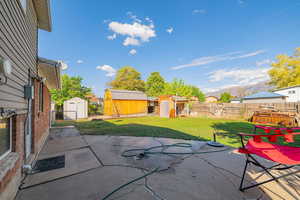 Fenced backyard featuring a shed, a patio area, and a mountain view
