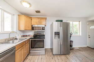 Kitchen featuring stainless steel appliances, light countertops, and light wood-style floors