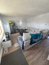Living room with wood finished floors and a textured ceiling