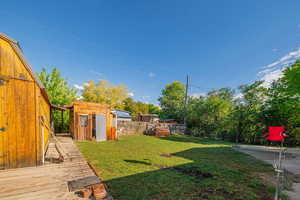 Fenced backyard with a shed and a wooden deck