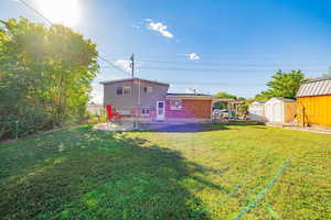 Back of house with a storage shed, a patio, a fenced backyard, and brick siding