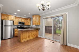 Kitchen featuring alder cabinets, quartz countertops, stainless steel appliances, recessed lighting, two-tone paint and crown molding