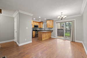 Kitchen featuring alder cabinets, quartz countertops, stainless steel appliances, recessed lighting, two-tone paint and crown molding