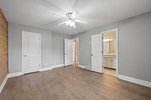 Primary bedroom featuring LVP flooring, two-tone paint, and ceiling fan