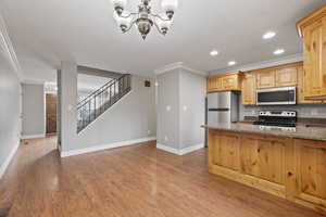 Kitchen with dining space featuring alder cabinets, quartz countertops, stainless steel appliances, recessed lighting and two-tone paint