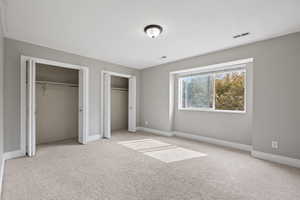 Second floor bedroom featuring two-tone paint, bay window, and carpeted flooring