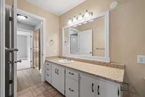 Primary bathroom featuring tile flooring and large vanity