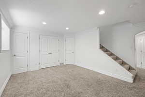 Basement living room with fresh paint, recessed lighting, and carpeted flooring