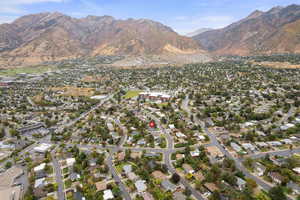 Aerial view of property and surrounding area with nearby suburban area and mountains