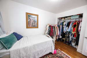 Bedroom featuring wood finished floors and a closet