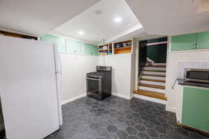 Kitchen featuring stainless steel appliances, open shelves, green cabinets, and recessed lighting