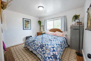Bedroom featuring wood finished floors and a textured ceiling