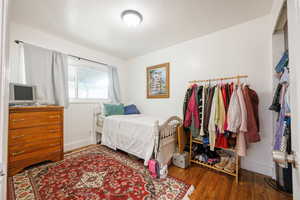 Bedroom with wood finished floors and baseboards