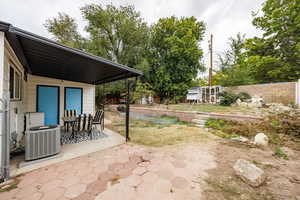 Fenced backyard with a patio, outdoor dining space, and an outbuilding