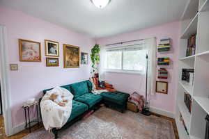 Sitting room with a textured ceiling and wood finished floors