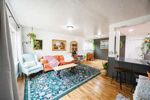 Living room with light wood-type flooring and a textured ceiling