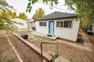 Rear view of house featuring a shingled roof and a patio