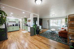 Living room with light wood-style floors and a textured ceiling