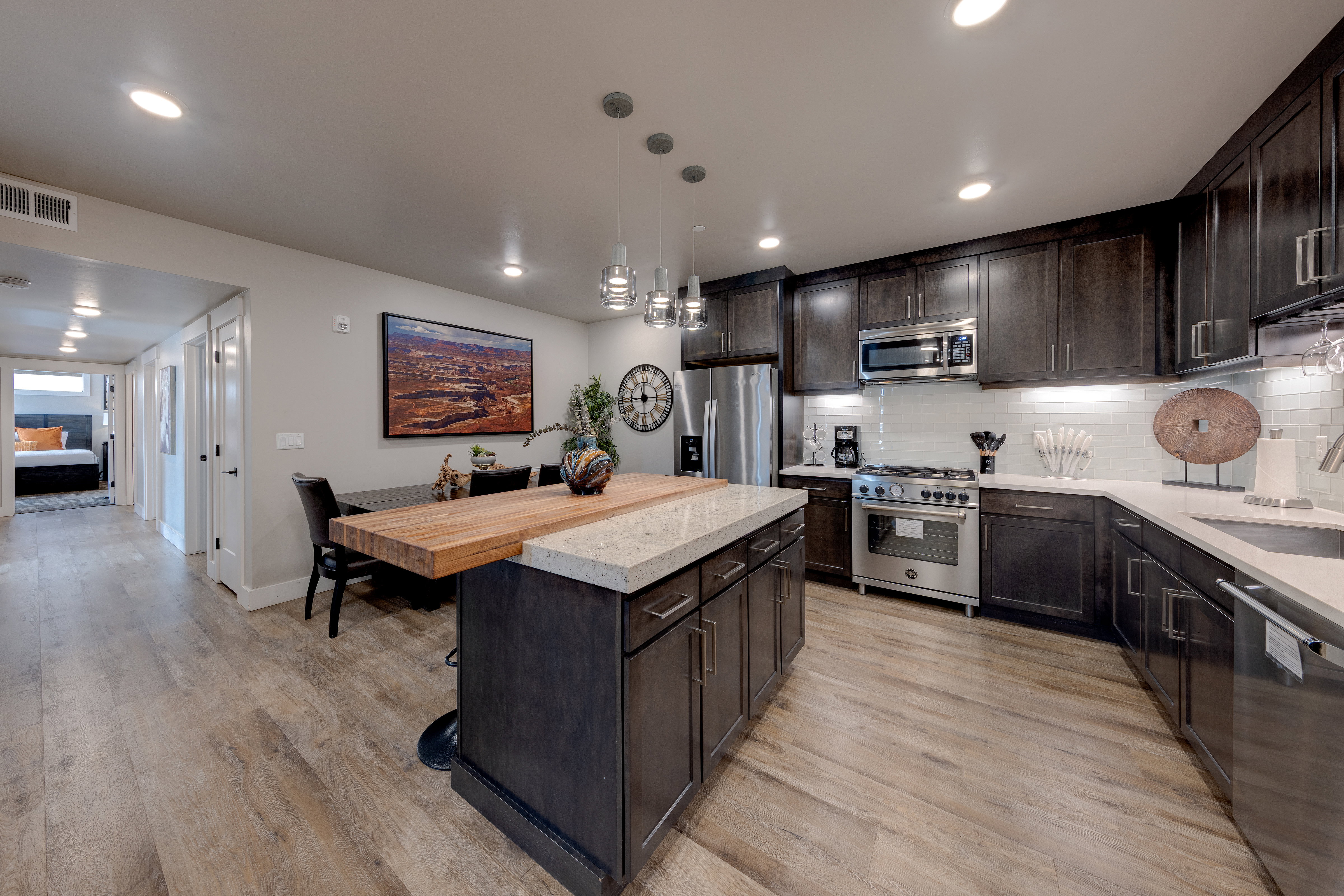 Kitchen featuring backsplash, dark brown cabinetry, a kitchen island, stainless steel appliances, and recessed lighting