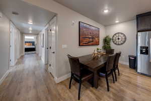 Dining room with light wood-type flooring and recessed lighting
