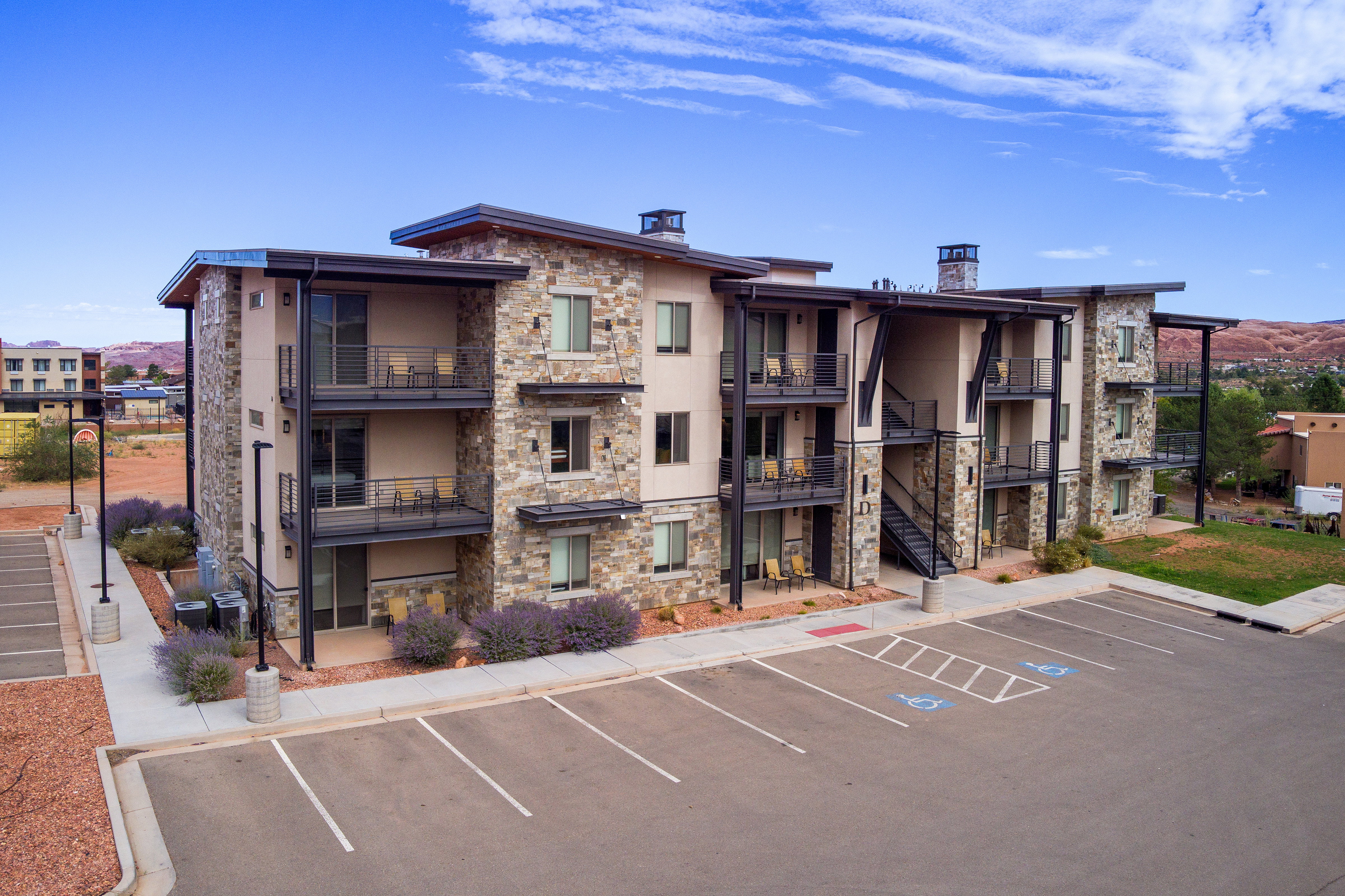 View of building exterior with uncovered parking and stairs