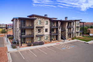 View of building exterior with uncovered parking and stairs