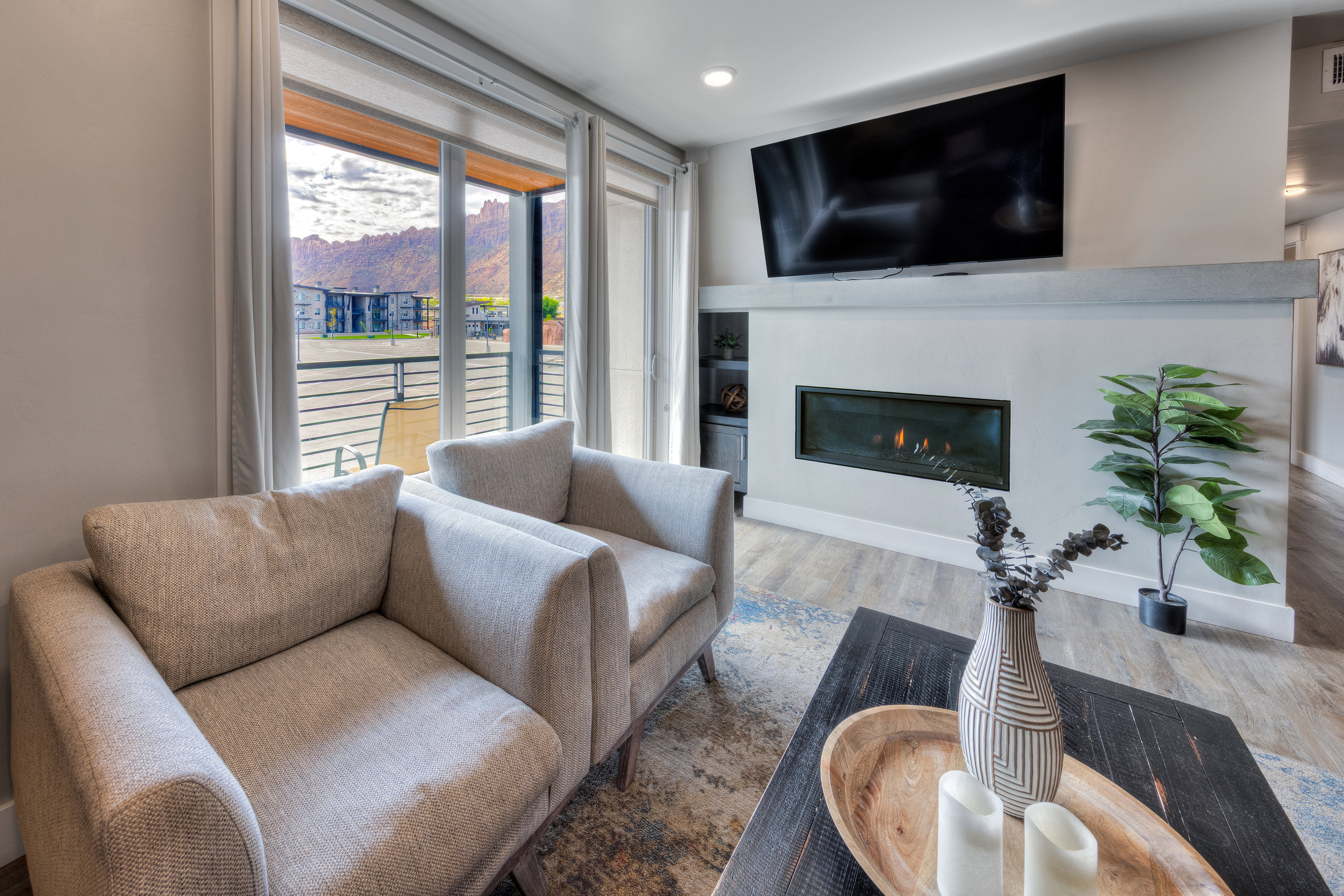 Living area featuring wood finished floors and a glass covered fireplace