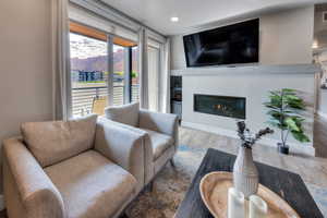 Living area featuring wood finished floors and a glass covered fireplace