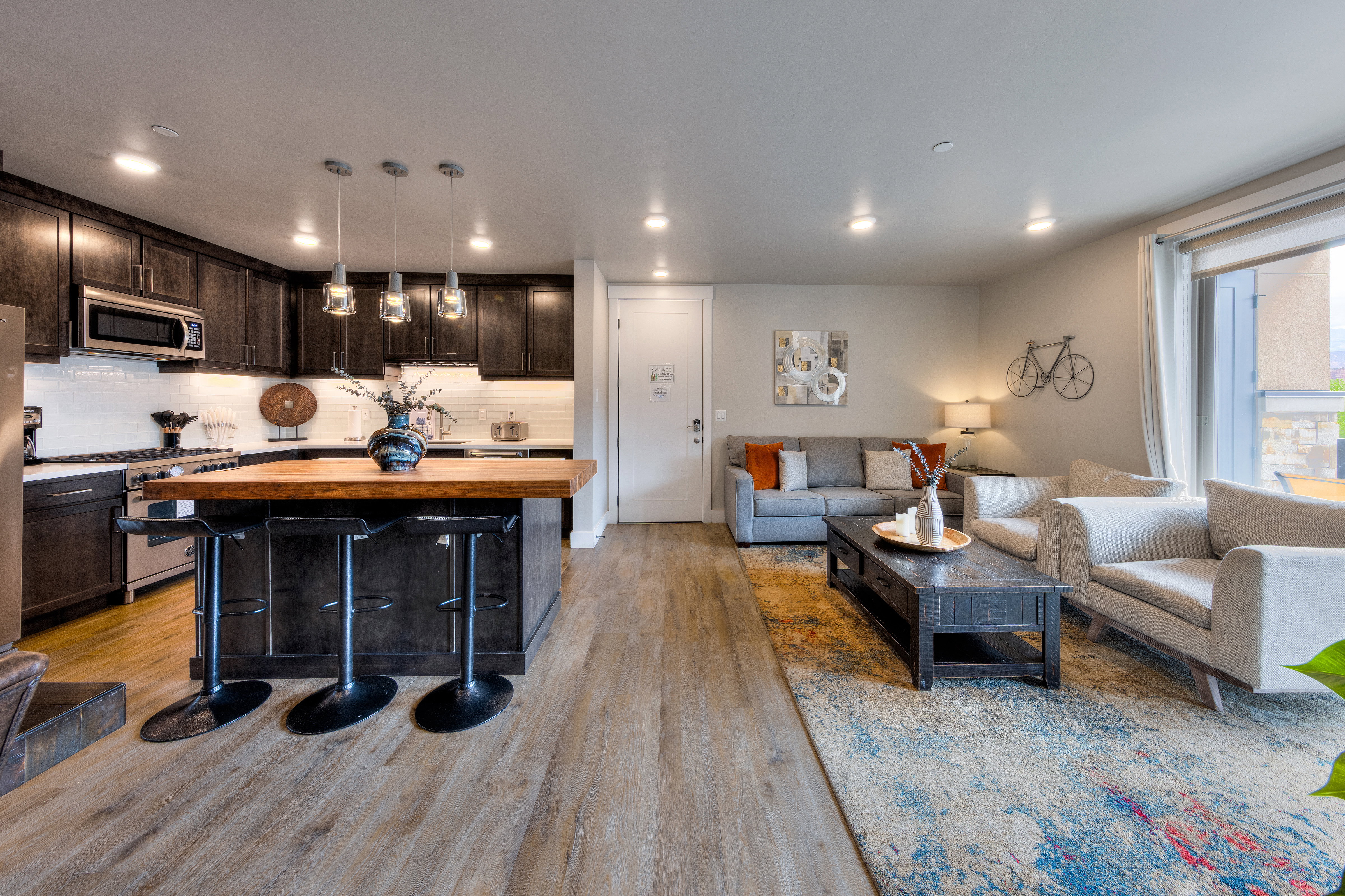 Living room with light wood-style flooring and recessed lighting