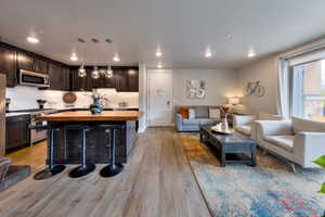 Living room with light wood-style flooring and recessed lighting
